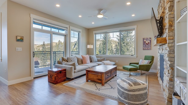 A spacious living room with a large window, a stone fireplace, and a cozy seating area. - Winter Park Condo w/ Balcony ~ 4 Mi to Slopes (Winter Park)