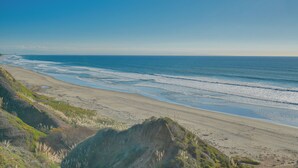 Ein Strand mit blauem Himmel und sanften Wellen.