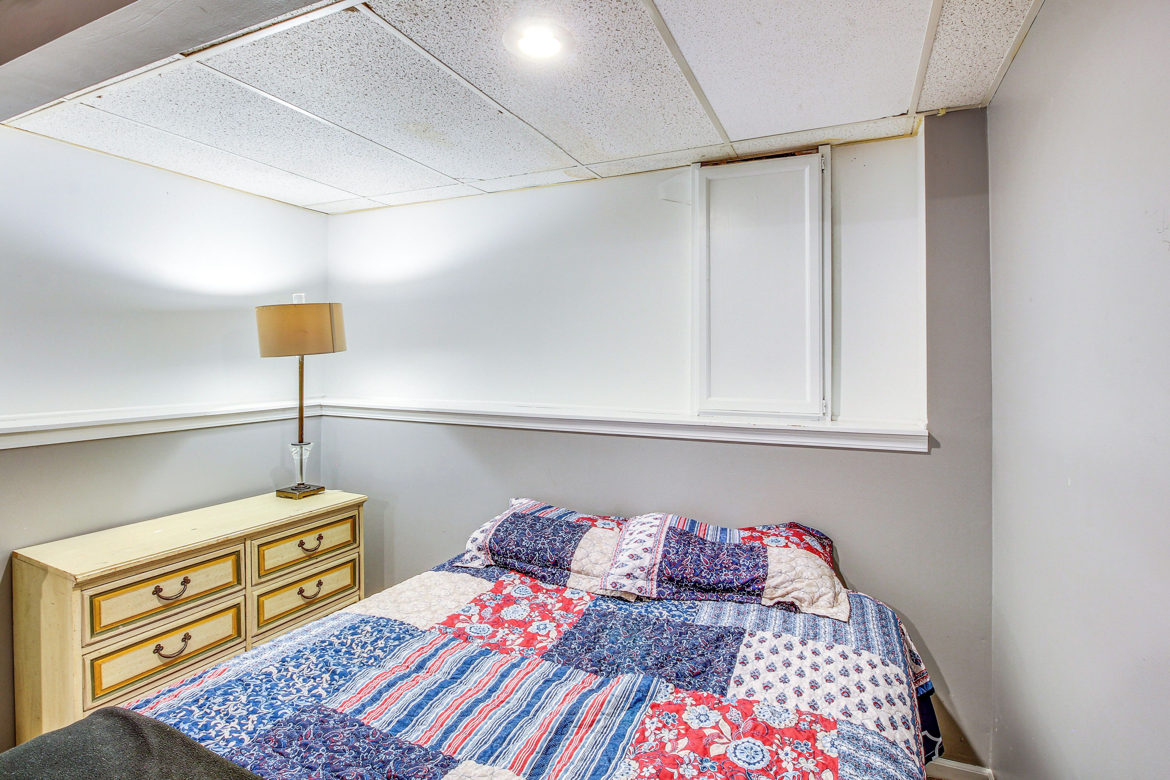 Een slaapkamer met een bed, een kaptafel, een lamp en een raam.