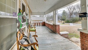 A covered porch with a wooden bench, a brick wall, and a view of the neighborhood. - Historic Aberdeen Vacation Home w/ Yard! (Aberdeen)