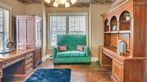 A room with a green velvet sofa, wooden cabinets, and a chandelier. - Historic Aberdeen Vacation Home w/ Yard! (Aberdeen)