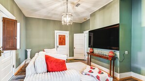 A bedroom with a large bed, a television, and a door leading to another room. - Historic Aberdeen Vacation Home w/ Yard! (Aberdeen)