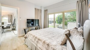 Une chambre à coucher avec un lit, une télévision et une grande fenêtre.