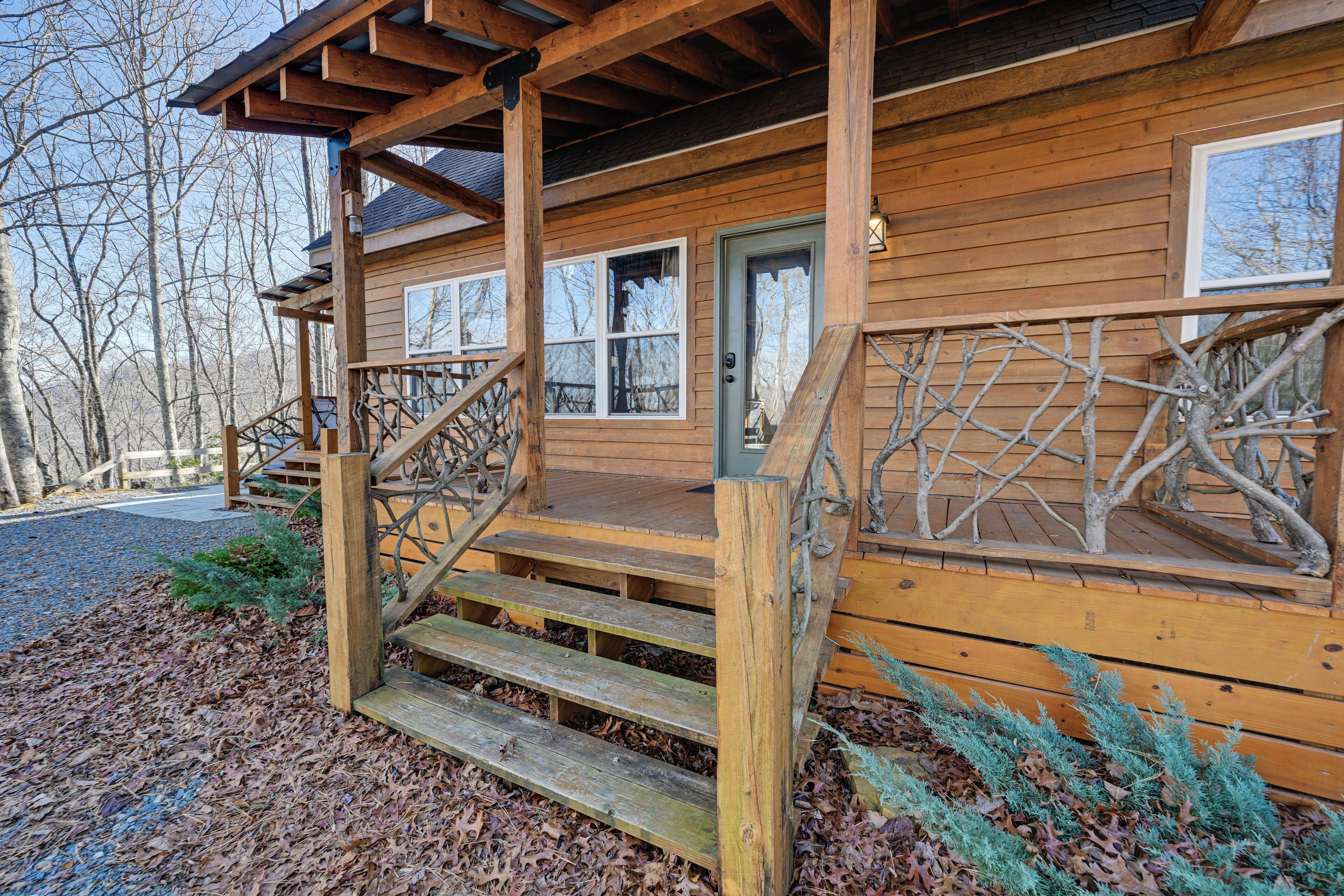A wooden cabin with a porch, wooden steps, and a window.