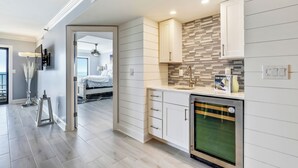 A modern kitchen with white cabinetry, a built-in oven, and a backsplash with a mosaic tile design.