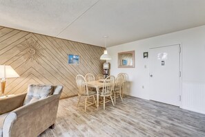A room with a herringbone-patterned wall, a dining table with chairs, a sofa, a lamp, and a clock on the wall. - DAILY ACTIVITIES & LINENS INCLUDED*! Mini-Week Flex turn day check in & check out any day. Based on Availability ( 3 night min.) (Ocean City)