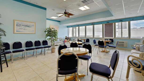 A conference room with a ceiling fan, a large window, and a painting on the wall.