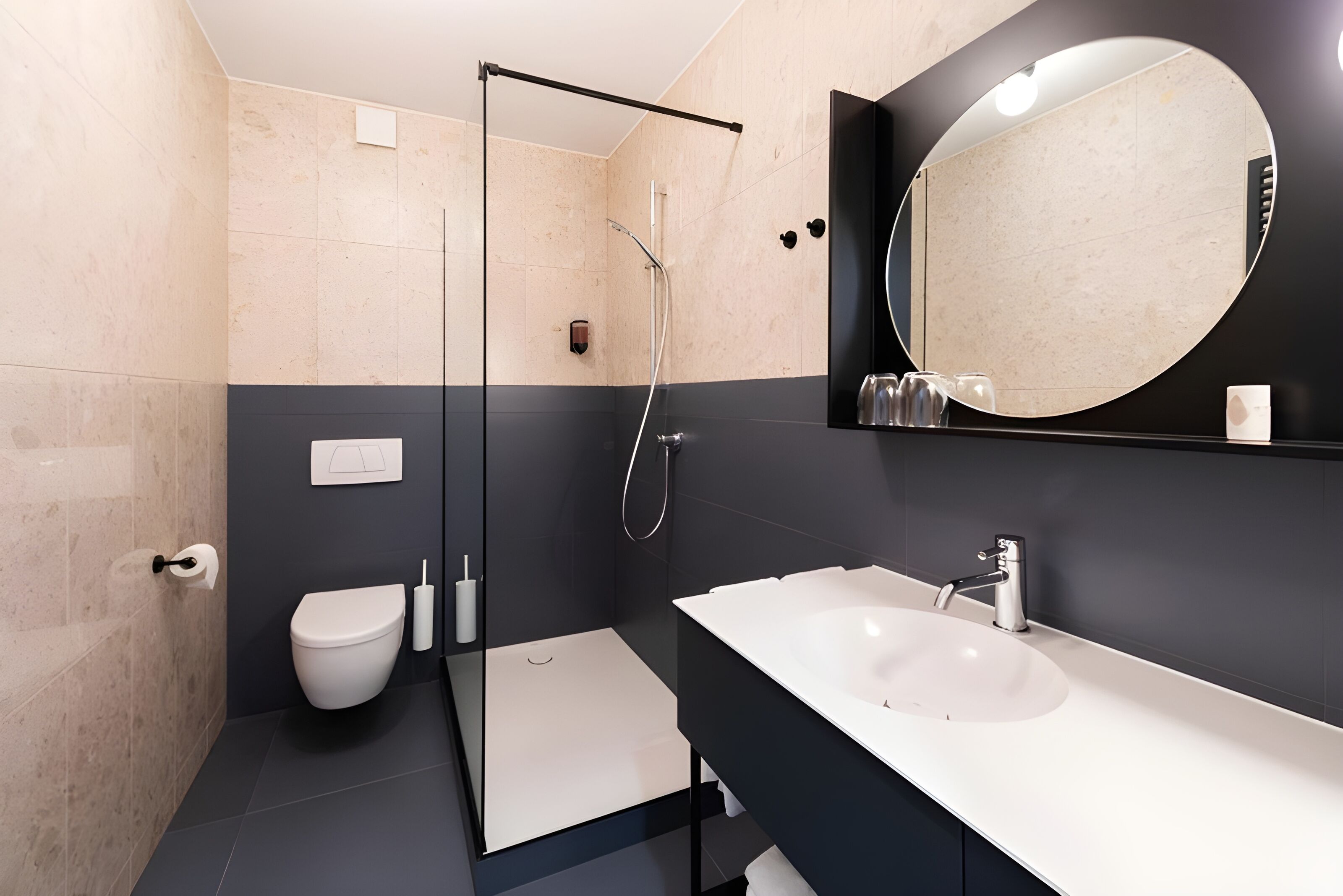 A modern bathroom with a glass shower enclosure, a white toilet, and a large mirror above a white sink.