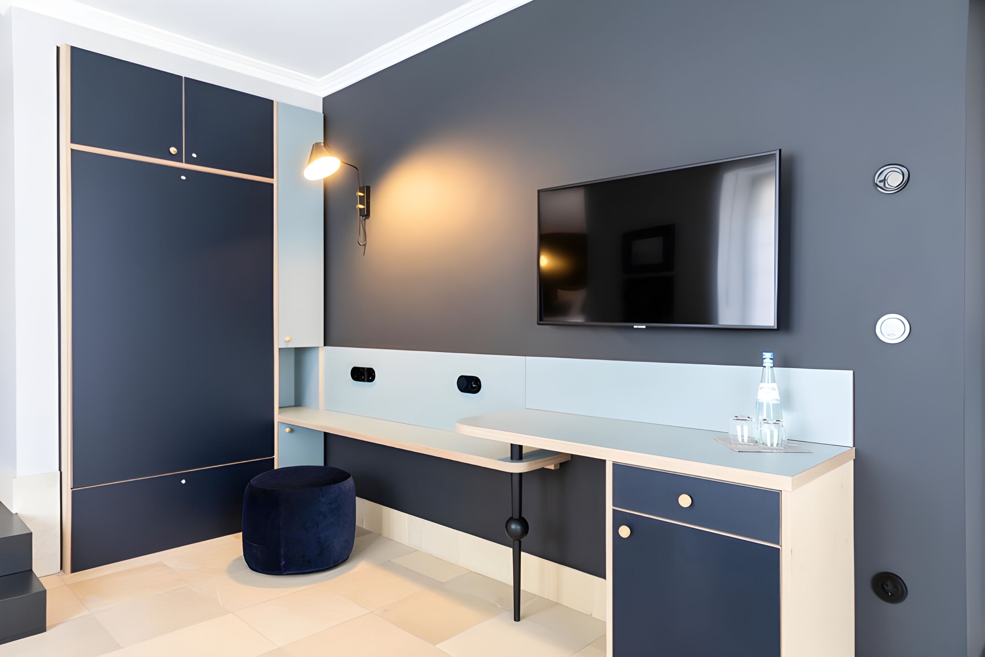 A modern bathroom with a dark wall, a white vanity, a black sink, and a large mirror.