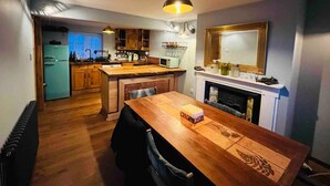 Uma cozinha compacta com armários de madeira, uma ilha central e uma mesa de jantar.