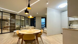 Cozinha moderna com mesa de jantar redonda, cadeiras e iluminação pendente.