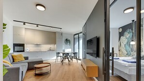 Um espaço de estar moderno com cozinha, área de refeições e quarto.