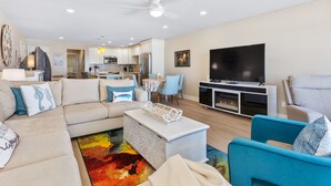 Una sala de estar moderna con sofá, mesa de centro y mueble para televisión.