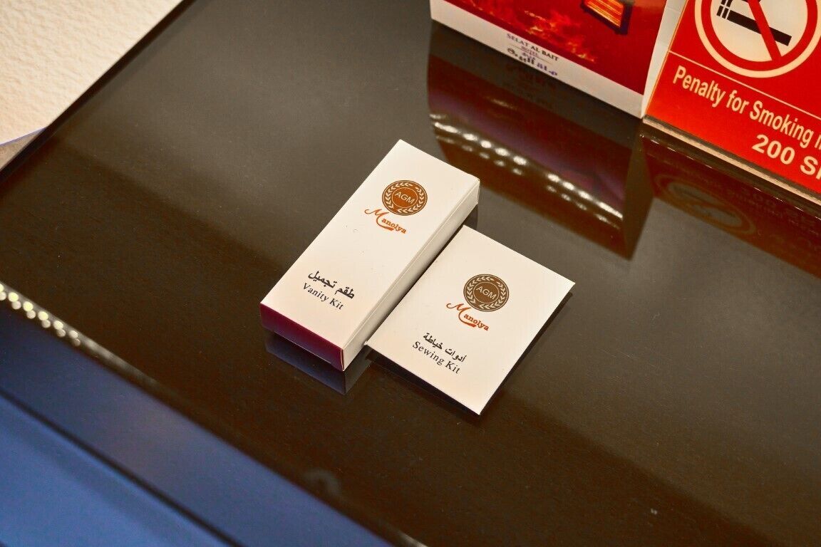Two boxes labeled "Vanity Kit" and "Sewing Kit" on a reflective surface.