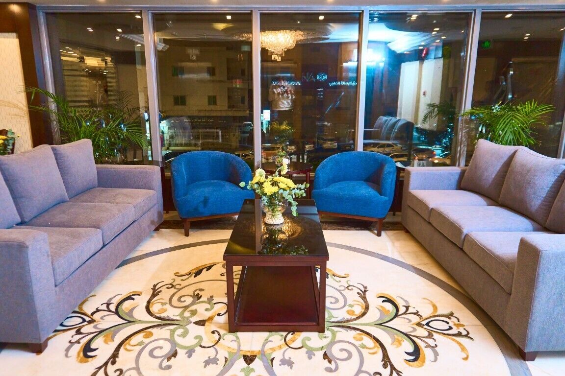 A lobby with two sofas, a coffee table, and a patterned rug.