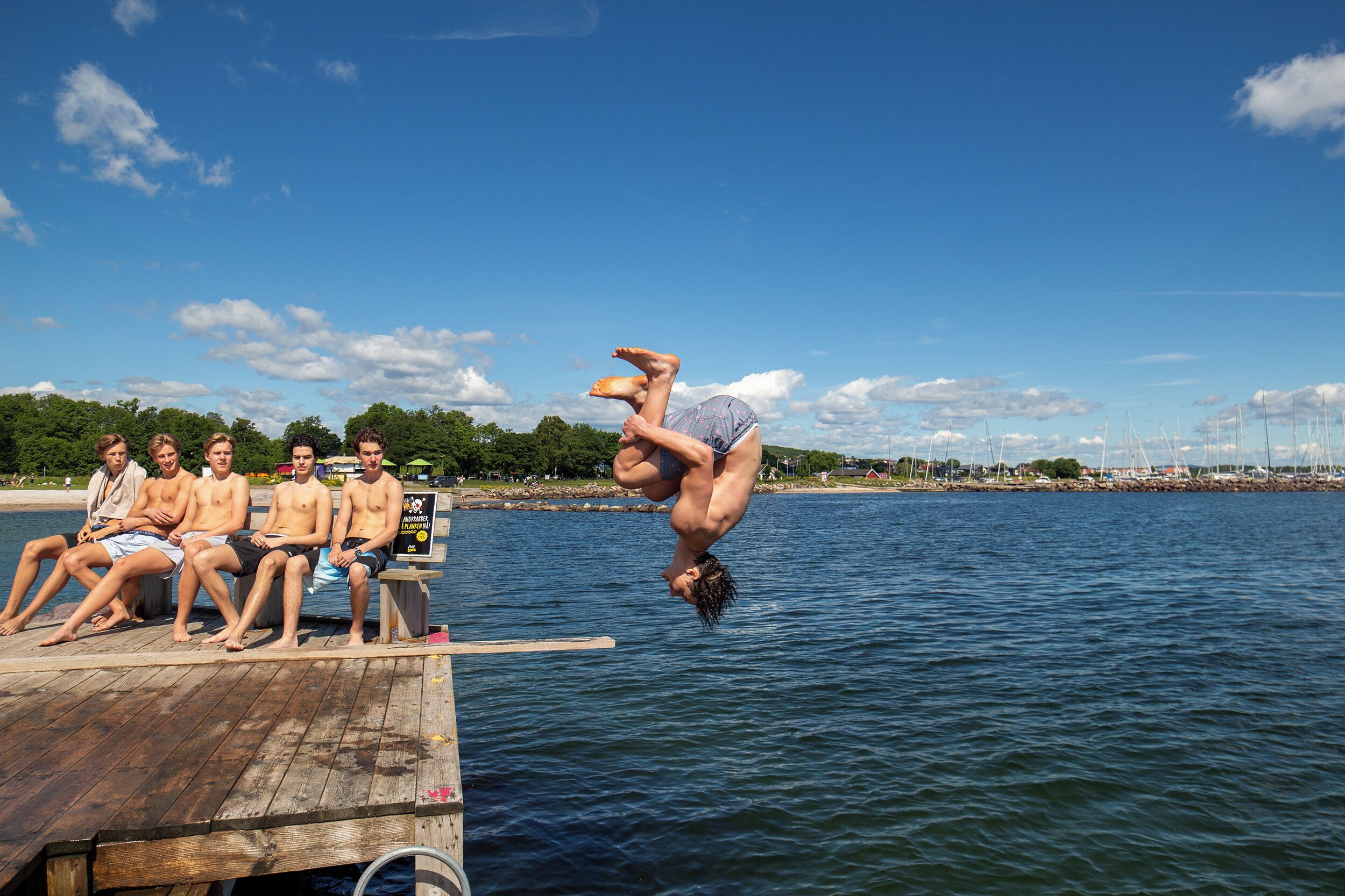 A wooden dock extending into a body of water with a clear sky above.