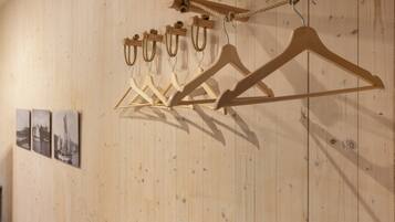 Wooden wall panels with a series of wooden hangers and a rope.