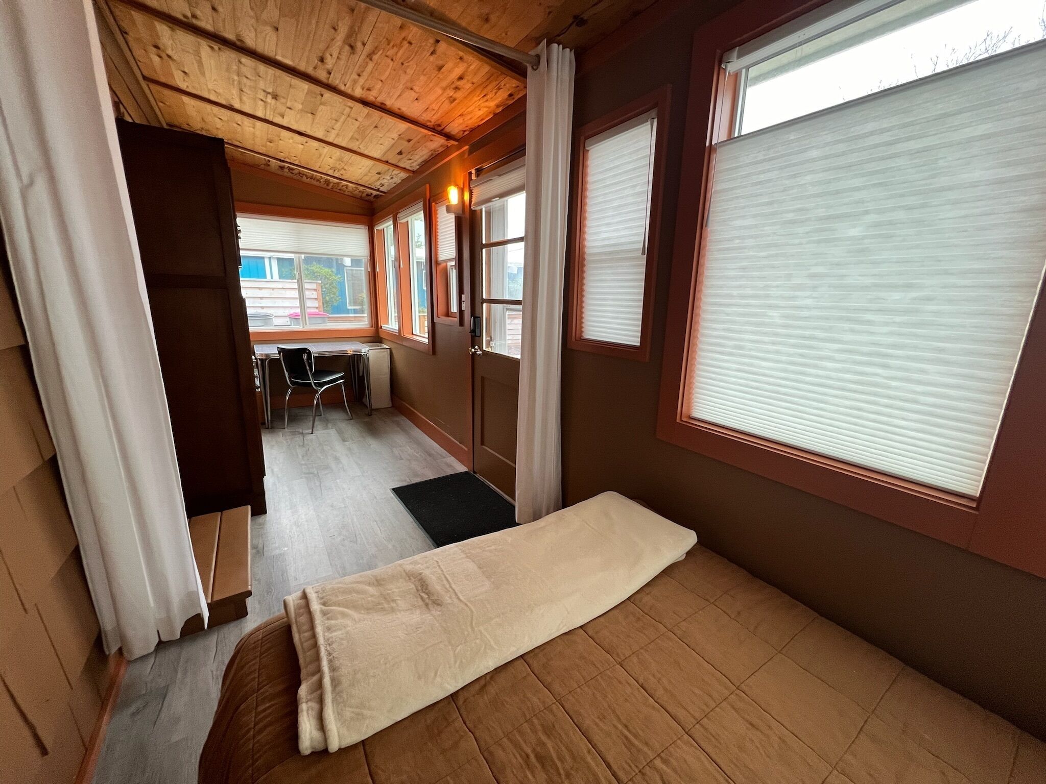 A compact room with a bed, a desk, and a chair.