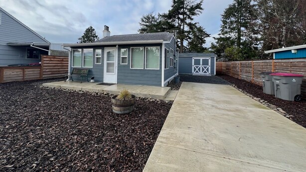 A small, single-story house with a front porch and a garage. - Close to Golf, Beach and Restaurants. (Seaside)