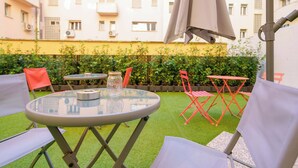 An outdoor seating area with a round table, chairs, and an umbrella. - Le stanze dell'Edera (Bologna)