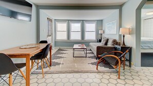 A compact hotel room with a dining area, a sofa, a small table, and a bed. - 🐚 Seaside Cottage A: Pet-Friendly Cottage, Steps to the Beach! 🐚 (Carolina Beach)