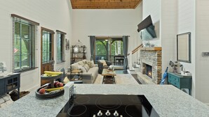 Ein geräumiges Wohnzimmer mit Kamin, eine Küche mit Granitarbeitsplatte und ein Essbereich mit Tisch und Stühlen.