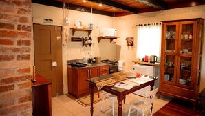 Una cocina con armarios de madera, una mesa de comedor y un horno empotrado.