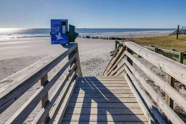 A wooden boardwalk leading to a beach with a sign about cigarette butt filters. - Beach Bungalow - freshly remodeled, oceanfront oasis! (Folly Beach)