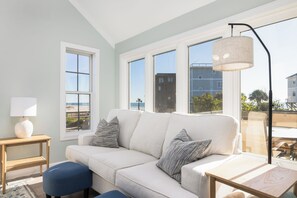 Una sala de estar moderna con un sofá blanco, una mesita auxiliar y una lámpara de pie.