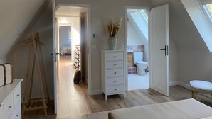 A bedroom with a sloped ceiling, a wooden ladder, a white dresser, and a bed. - Domitille Deluxe Room Garden View (Lamonzie-Montastruc)