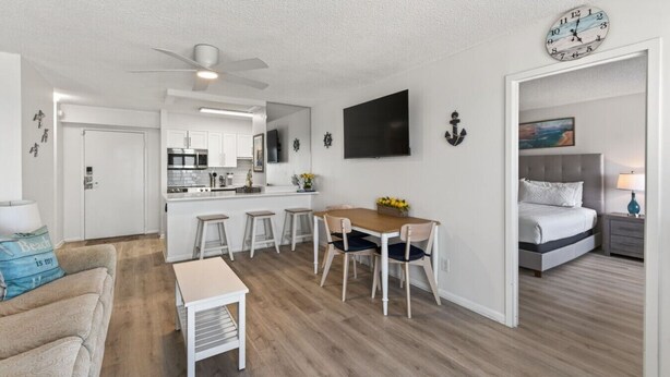 A modern apartment with a kitchen, dining area, and a bedroom.