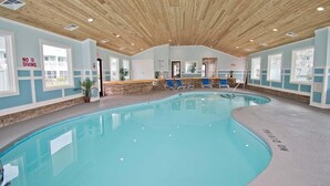 Een binnenzwembad met een houten plafond, blauwe wanden en een bordje met de tekst 'No Diving'.