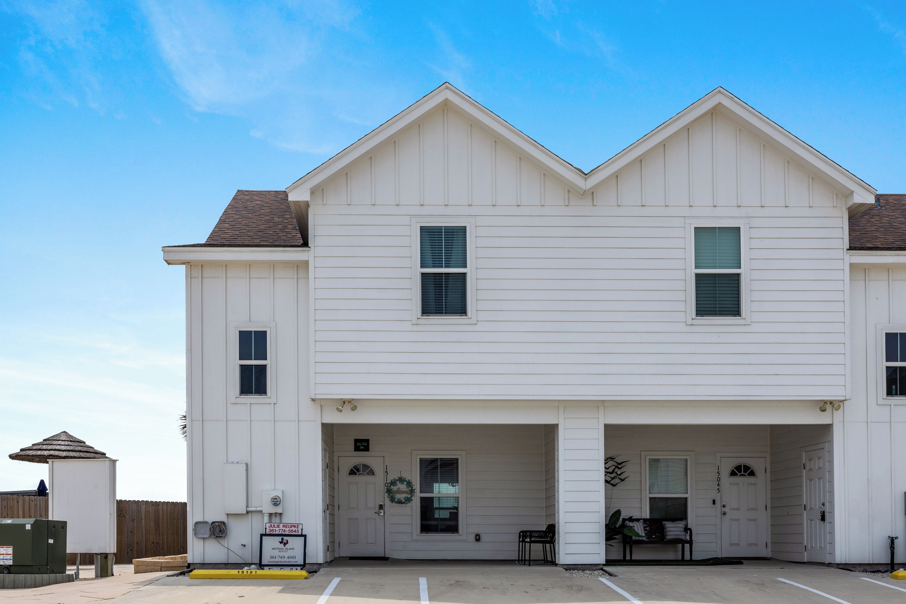 A two-story building with a central entrance and a covered porch.