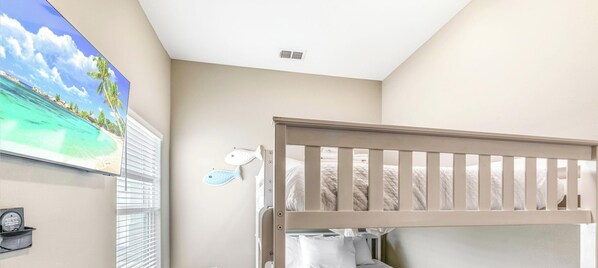 A room with a bunk bed, a wall-mounted fish decoration, a framed picture, and a window with blinds. - Coastal Escape | Heated Pool, Pirate Playground & Beach Steps (Corpus Christi)