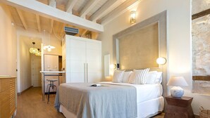 Un dormitorio con cama, mesita de noche, lámpara y un espejo grande.