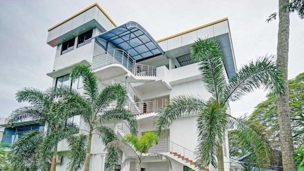 A modern multi-story building with a prominent staircase, balconies, and a glass roof structure. - Diamond Residency (Ambalapuzha)