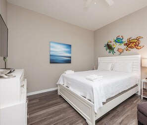 A bedroom with a bed, a desk, and a wall-mounted artwork. - Pet-Friendly Beach Escape | Two Heated Pools (Corpus Christi)