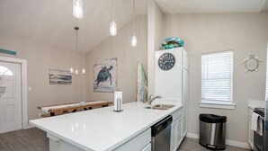 A kitchen with a white countertop, stainless steel appliances, and a clock on the wall. - Luxury Townhome | Private Patio, 2 Heated Pools & Amenities (Corpus Christi)