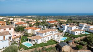 A coastal residential area with white houses, a swimming pool, and a view of the sea. - Bellevue 36B by Klodge - flat with pool and views (Budoni)
