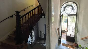 Escada com corrimão e porta que dá para área externa com portão.