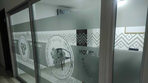 A hotel reception area with a glass door featuring a logo and the word "HOTEL" visible. - HOTEL LA CASA No. 1 (Montería)