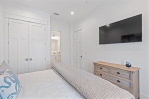 A bedroom with a bed, a dresser, and a TV mounted on the wall. - BRAND NEW HOME-Marlin Time-The Osprey-Signature Properties (Orange Beach)