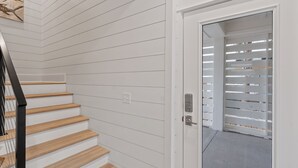 A staircase with wooden steps and a white wall with horizontal lines.