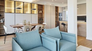 Un salon moderne avec un canapé bleu clair, une table à manger en bois et des étagères intégrées.