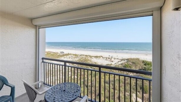 A balcony with a view of the beach.