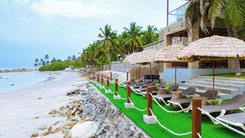 On the beach, sun-loungers, beach umbrellas, beach bar