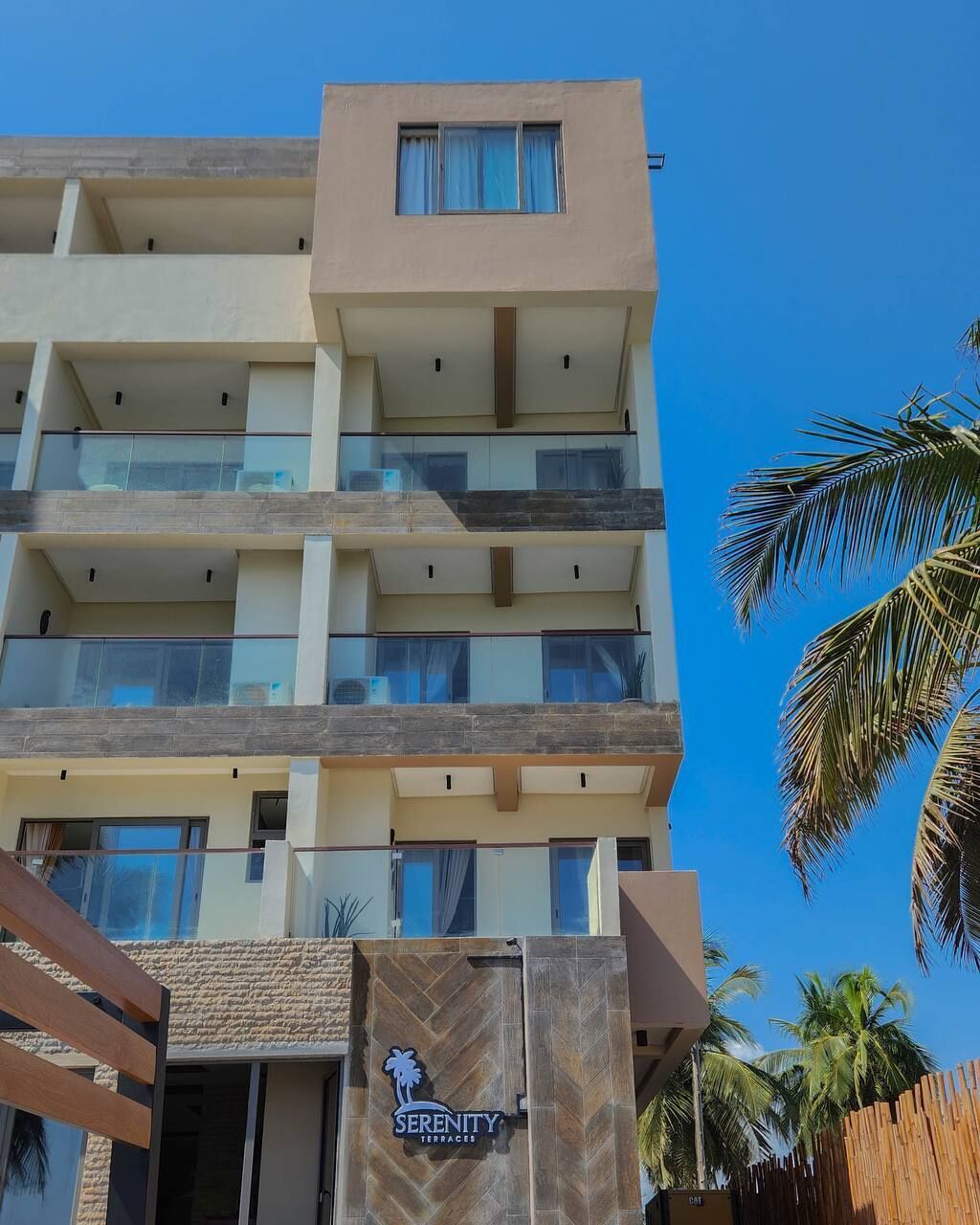 Um hotel com vários andares, design moderno, com varandas e grandes janelas.