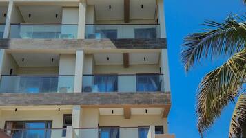 Um hotel com vários andares, design moderno, com varandas e grandes janelas.