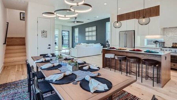 A modern kitchen with a central island, bar stools, and pendant lighting. - Dip into the 512 Experience! 6 BDRMS W/Pool Mins to DT (Austin)