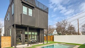 A modern two-story house with a pool, large windows, and a covered patio area. - Dip into the 512 Experience! 6 BDRMS W/Pool Mins to DT (Austin)